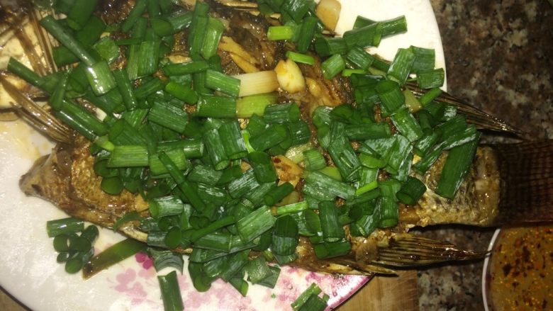 香煎非洲鱼。,撒上葱花。