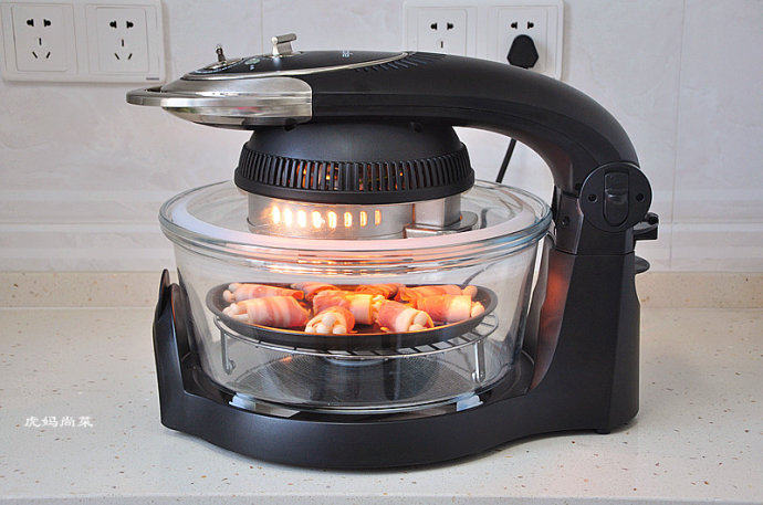 风味十足的培根豆腐皮蘑菇卷,将烤盘放入空气炸锅中的旋转烤架上，设定205度，8分钟，盖上盖子，开始烘烤。
   旋转烤架一定要放，这样转着烤更会受热均匀。
   烤培根卷，尽量用最高温，这样既能快速的烤熟培根，逼出油，还能保住蘑菇不流失太多水份