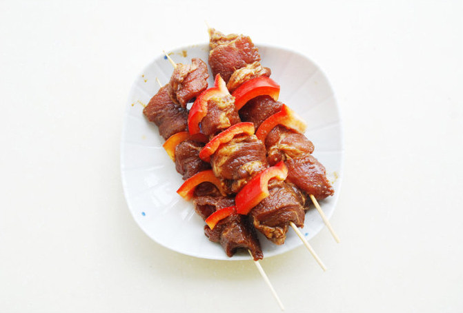 【电烤肉串】,将腌好的烤肉串在竹签上;