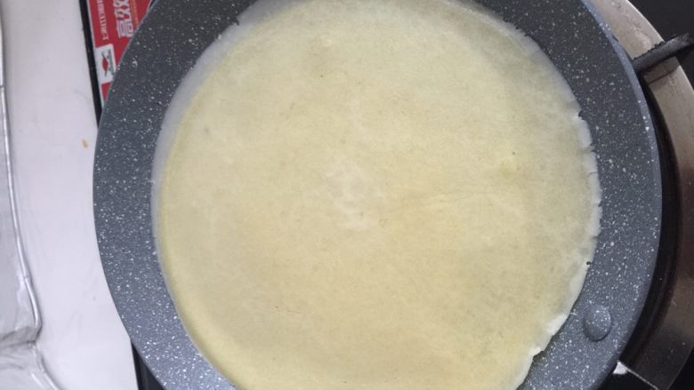 水果可丽饼,一个小时后,用蛋抽再搅一下蛋糊,如果有发硬或者太浓稠,可加入一点点清水。不粘锅小火,倒入一大勺蛋糊夜,然后迅速转一圈锅,让蛋糊绕成圆形。