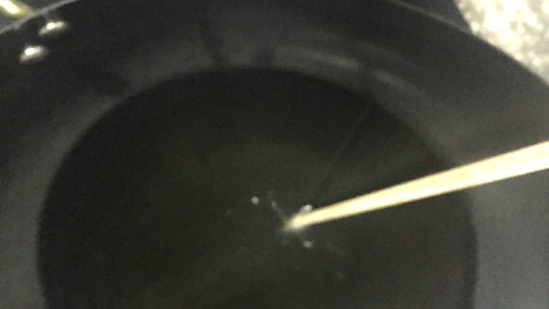南瓜饼,倒入适量的食用油,多少以能盖住南瓜饼为适宜吧!这都无所谓,因为煎也是可以的。只是炸要快一点,炸起来也会好看一些。
放入一根干的筷子,看到筷子周围冒小泡时,放入南瓜饼