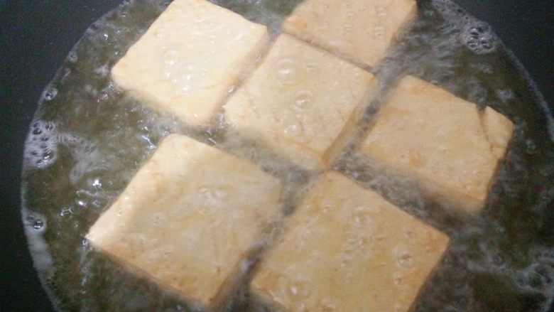 卤豆干,一面炸至金黄后翻面,继续炸