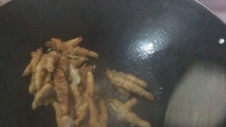 芙蓉鸡爪。,锅里放油,加入鸡爪翻炒