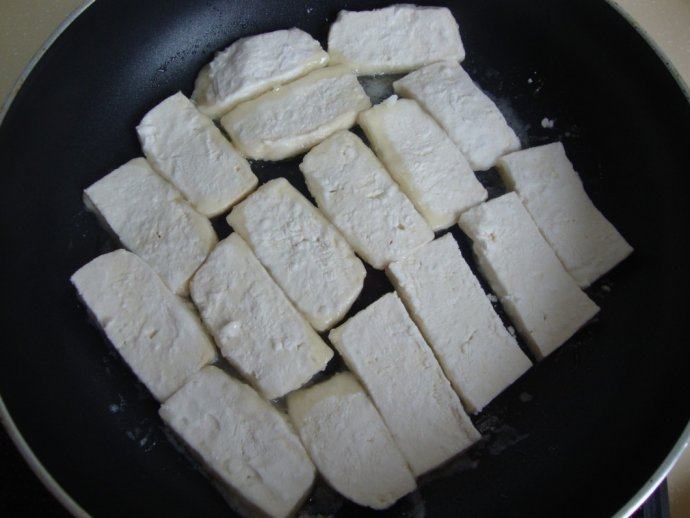 简单搭配：培根烧豆腐 ,放入煎好的豆腐，加水、盐、<a style='color:red;display:inline-block;' href='/shicai/ 10588'>糖</a>、胡椒粉调味，烧制一会儿