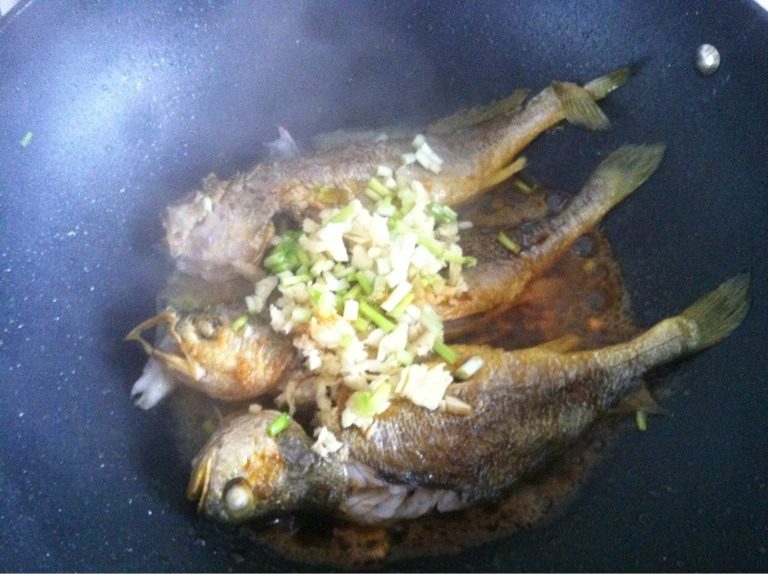 蒜煎海鱼,煎至六成熟把剁好的姜葱蒜放到鱼面上