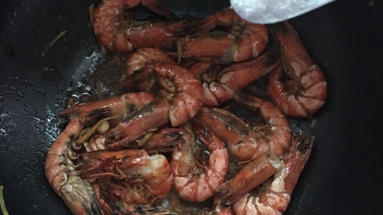#年夜饭#酱爆鲜虾,放入酱油翻炒均匀,加入适量的盐和两勺白糖调味炒匀。