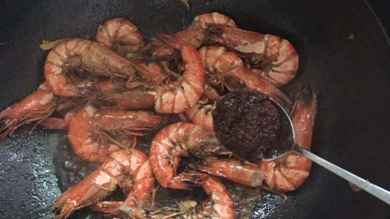 #年夜饭#酱爆鲜虾,加入一大勺沙茶酱和两勺料酒,炒匀。