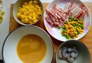 海鲜菠萝炒饭,<a style='color:red;display:inline-block;' href='/shicai/ 507'>米饭</a>（水比平时的<a style='color:red;display:inline-block;' href='/shicai/ 507'>米饭</a>略少一些）煮熟后用饭勺拨松放凉备用；<a style='color:red;display:inline-block;' href='/shicai/ 287'>虾仁</a>挑去虾线放入适量<a style='color:red;display:inline-block;' href='/shicai/ 718'>料酒</a>、<a style='color:red;display:inline-block;' href='/shicai/ 134340'>黑胡椒粉</a>和盐腌制片刻后入沸水煮熟取出；蟹肉棒撕成小细丝；<a style='color:red;display:inline-block;' href='/shicai/ 140513'>速冻玉米</a>和青豆解冻沥干水。