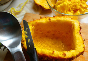 海鲜菠萝炒饭,菠萝洗净后在侧面约三分之一处切开，用小刀和小勺子小心的取出内部果肉，取约一小碗的果肉切成小丁备用。