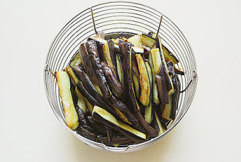 开胃下饭的绝味小凉菜【剔骨肉拌茄子】,锅加少许油，将茄子条放入锅中煎至两面焦黄取出；