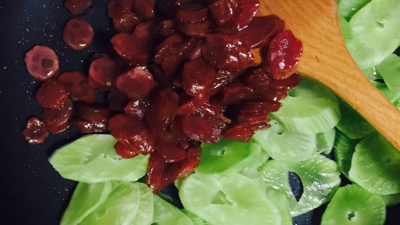 莴苣炒香肠,倒入香肠翻炒。加入耗油