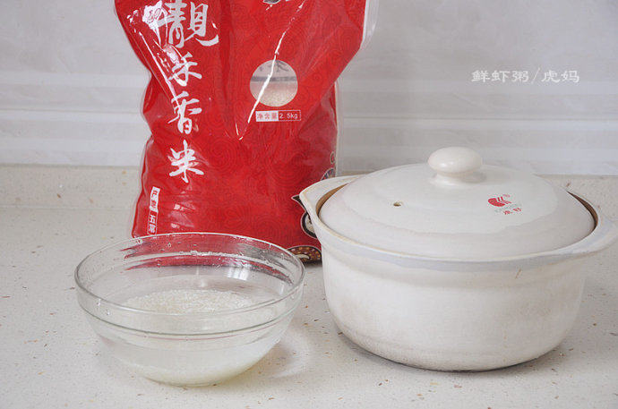 仙气儿十足的鲜虾粥 ,提前将大米洗净，然后浸泡一小时，这样熬的粥更粘稠。
   我的砂锅直径22cm，高10cm，放满水煮粥，一般需要3或4把大米，放4把浓稠些，3把就稀些。
   这个砂锅上次被烧黑了后，虎爹在楼下用邻居装修用的沙子，费劲搓了半天，让它恢复了往日的干净白色。也谢谢博友给的这个用沙子搓的好办法。