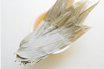 粽香飘万里【粽香排骨】,干粽叶放入沸水中,再次煮沸保持沸腾半分钟左右,捞出冲净,放入清水中浸泡待用;