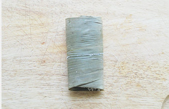 粽香飘万里【粽香排骨】,用棉线捆起,扎紧码入盘中;