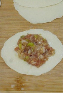 猪肉大葱饺子 ,擀好的饺子皮中间放入适量的馅料,把饺子皮托起,卡在手的虎口处让它自然形成对折,
然后将边缘依次折合捏紧,使饺子皮完全粘合即可。