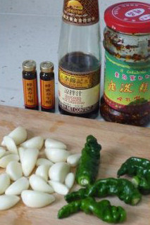 【凉拌酸辣黑啤猪蹄】,焖煮猪蹄时,可以将凉拌汁的材料准备好,大蒜剥皮,薄皮青椒洗净去籽。