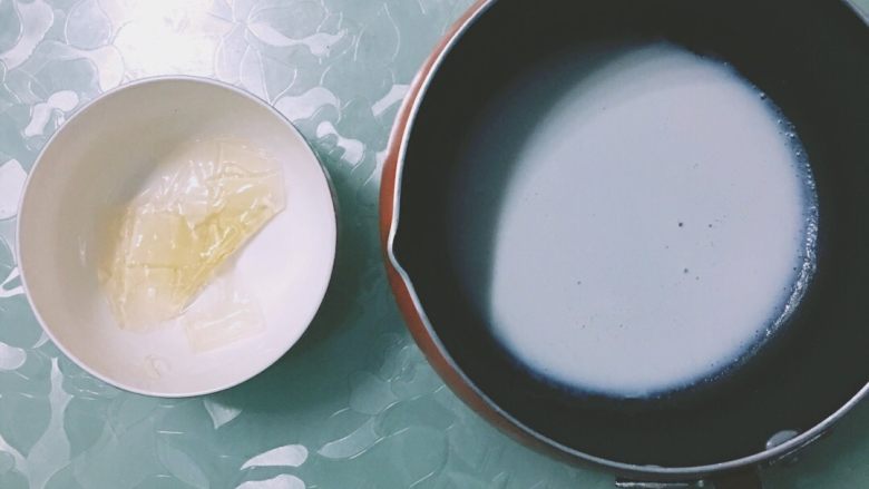 抹茶红豆冻芝士,吉利丁片放入少量凉水泡软,把凉水倒出。<a style='color:red;display:inline-block;' href='/shicai/ 219'><a style='color:red;display:inline-block;' href='/shicai/ 219'>牛奶</a></a>小火加热,倒入泡软的吉利丁片中,搅拌至完全融化