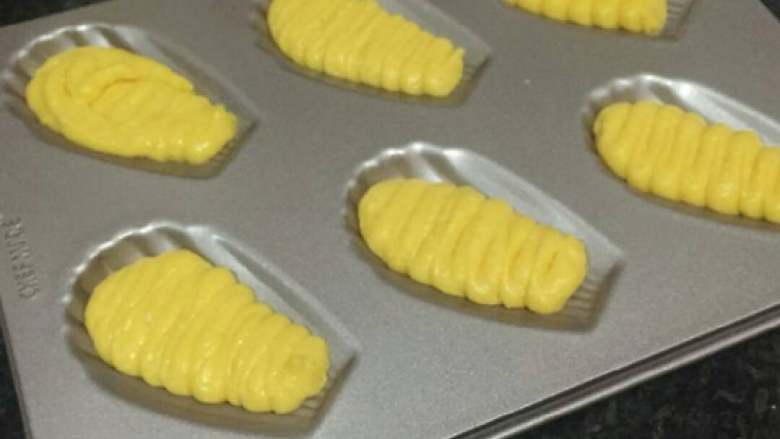 椰香玛德琳,烤箱预热180°,面糊挤入模具中,因为烘烤时面糊会极速膨胀,所以只要八分满就OK啦