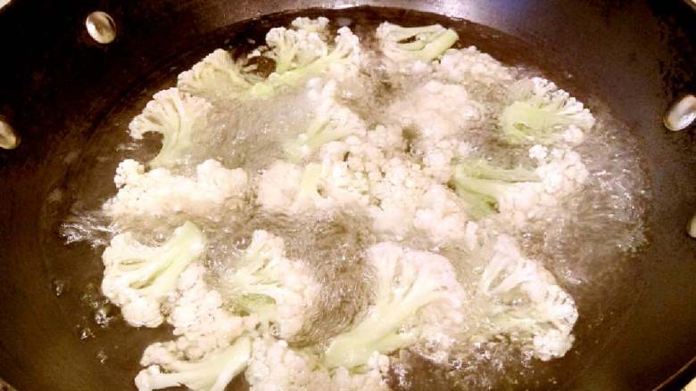 花菜炒肉片,锅里放水500克烧沸,下花菜煮三分钟捞起沥干待用。