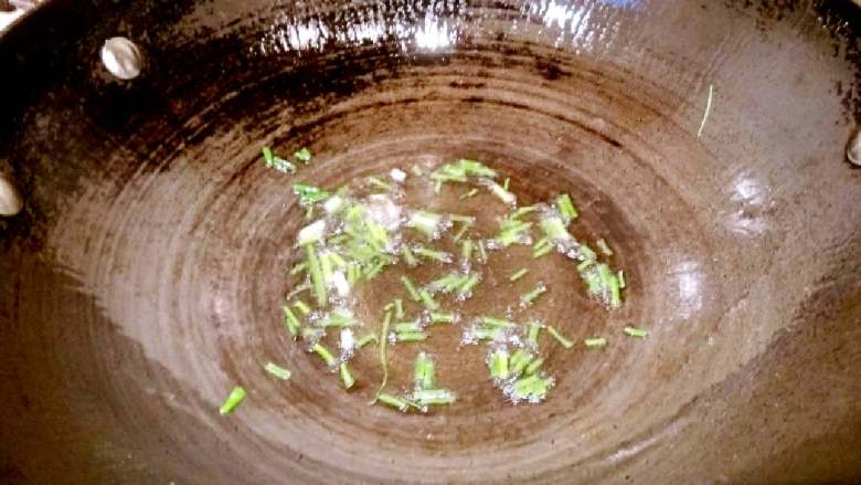花菜炒肉片,锅里放油适量,油八成热放入葱花爆香