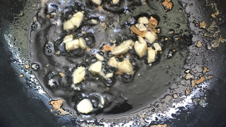 韭苔炒豆腐,锅内留少许的油,放入蒜瓣爆香。剩下的用干净无水的盆装上,可以平时做菜。