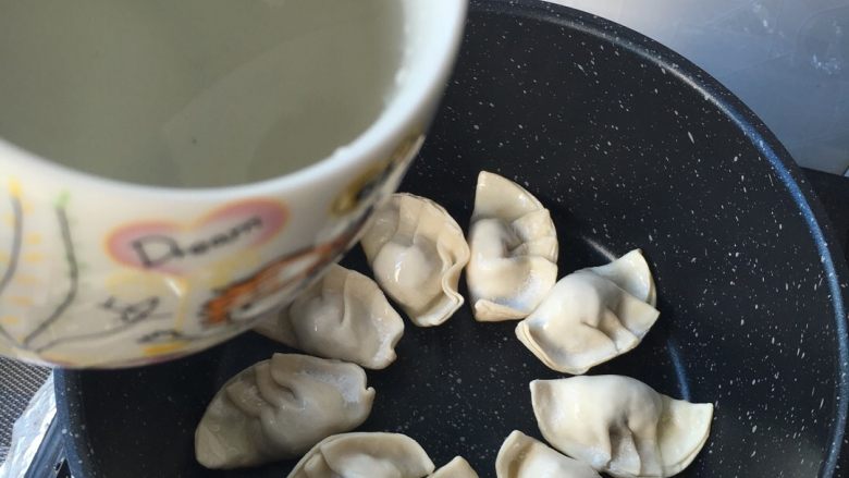 鸡蛋煎饺,煎上一两分钟,加入清水没到饺子的一半