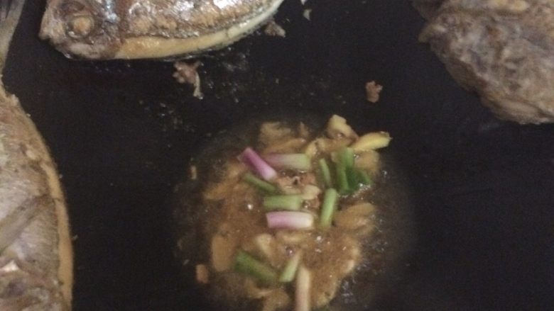 海鱼美味中餐,把鱼放锅的上端,锅里剩少许油,加入姜蒜葱头,再加入鸡粉,花椒粉,青椒,红椒,生抽,加入一碗凉开水。