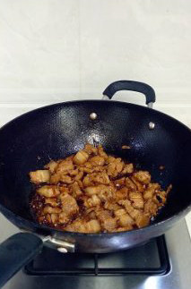 经典家常菜干豆角红烧肉,倒入肉片翻炒数下后加入生抽，继续翻炒至肥肉颜色呈半透明状。