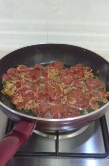 不腥不柴的滑蛋牛肉饭,锅中油热后葱姜末炝锅,倒入牛肉片,大火快速翻炒至一半的牛肉变色。