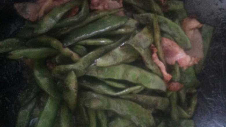 东北猪肉南瓜顿豆角,锅加油放猪肉片和豆角煸炒,放一点小苏打,炒到豆角发软。