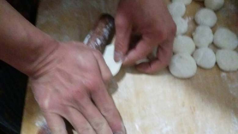 蓬莱饺子,一手不停旋转剂子一手用擀面杖擀面皮,擀到中间厚边上薄为止,上面不要撒太多干面,要不不好包了。