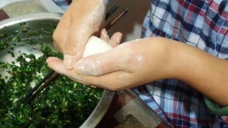 蓬莱饺子,左手平放面皮,右手放入合适馅料(初学不要太多)先把中间捏死,两手拇指和食指分别捏住两边用力边捏边往中间对压。