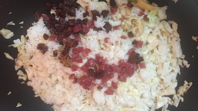 腊味蛋炒饭(约二人份),倒入腊肠粒翻炒均匀