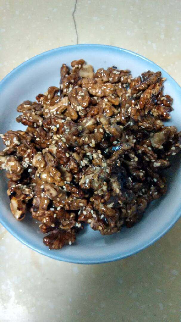 琥珀核桃仁,下核桃仁至糖浆铲匀,加入白芝麻合匀,装盘放凉,酥脆。