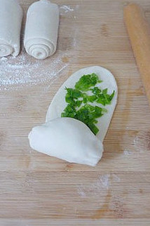 【葱油饼】,轻轻卷起,卷的同时要顺便将边缘部分捏紧。