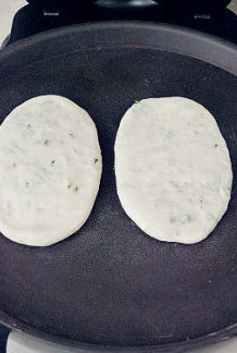 【葱油饼】,放入预热好的电饼铛,盖上盖子,1-2分钟后掀开翻面。