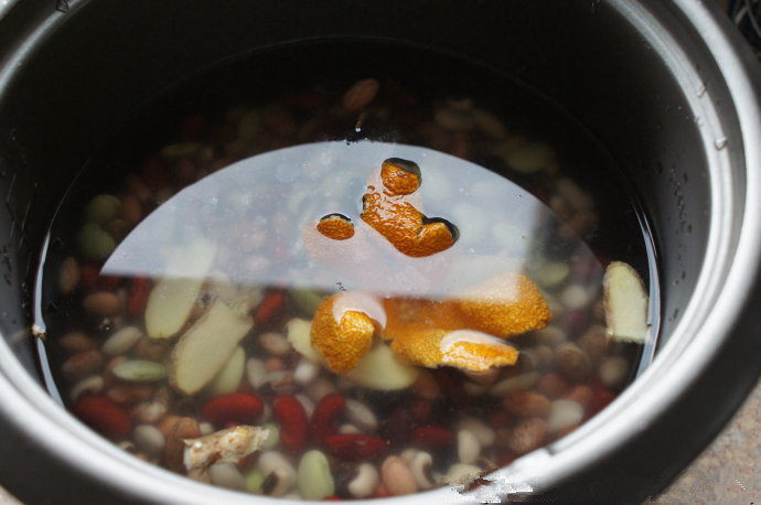姜味陈皮八宝粥(电饭锅版本),把什锦豆,米,姜,陈皮放入电饭锅,加适量水,盖上锅盖,按相应功能键熬煮。