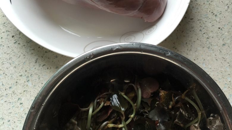 金线莲猪心汤,材料准备好。金线莲用清水浸泡,轻轻洗去根茎上的杂质。猪心切开一边,洗去里面的血块,把里面的筋膜剪掉,洗净备用。