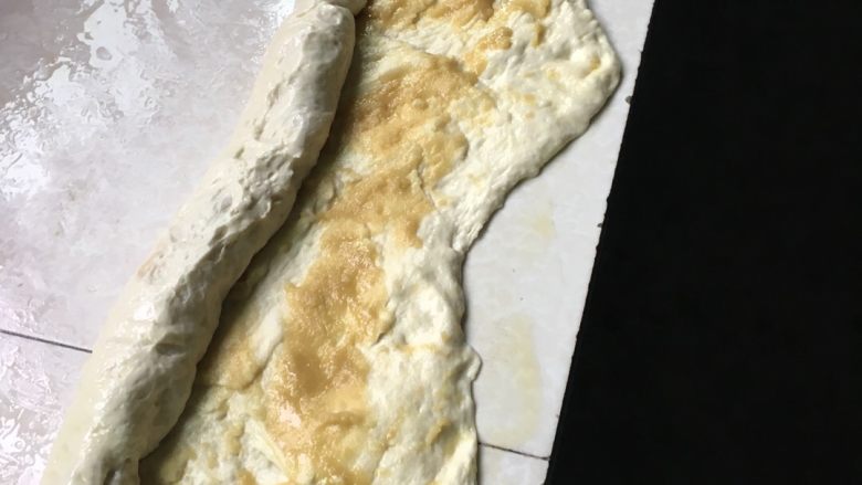 油酥火烧,将发酵好的面粉在案板上摸上油,双手抹上油在把面团悄悄揉一下排气,最后把面团赶开,把油酥均匀抹在面皮上,在卷起来