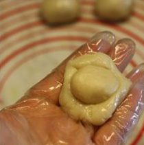 【蛋黄酥】,把小面团从中间按扁,擀成圆形,把小面团包入豆沙红豆沙馅,收口收紧