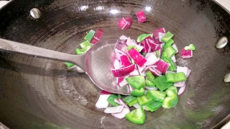 咖喱鸡块饭,锅里放油适量,油八成热下洋葱青椒翻炒