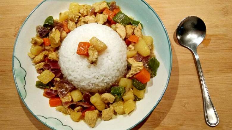 咖喱鸡块饭,盘子当中放饭,把做好的咖喱鸡放旁边。美味的咖喱鸡块饭完成