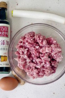 徐州过年头牌美食—猪肉饺子,将葱、姜切碎末,猪肉放料理机里搅打成泥后倒入碗中。