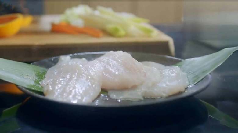 锋味纸包鱼,在鱼身上撒上少量盐、黑胡椒,腌渍入味。这道菜不需要放太多的调料,主要是吃鱼本身的鲜味。