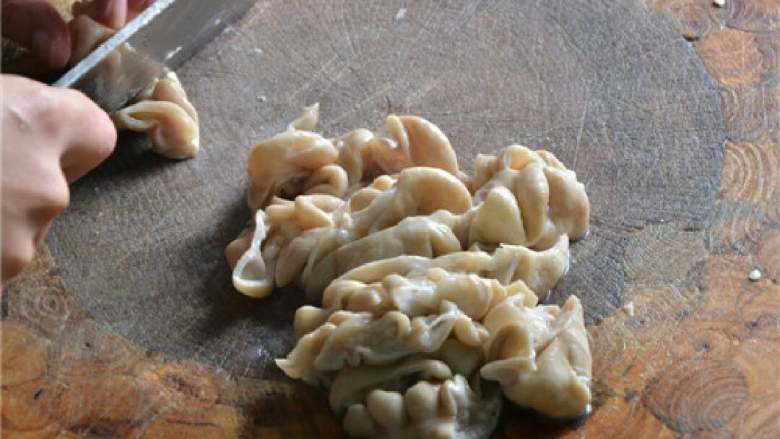 干煸肥肠,将煮好的肥肠取出来,沥干水分,也切成滚刀块。