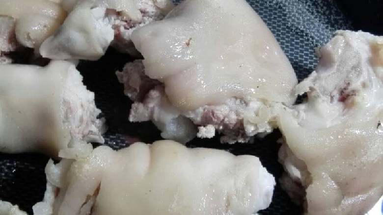 “水煮麻辣猪蹄”绅士私房菜,先用开水过一遍去一下血水,然在锅内烧油俩面给它煎一下