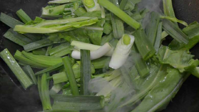 水煮肉片,锅里放入油，倒入蒜苗节和青笋叶，加入少量盐炒匀。