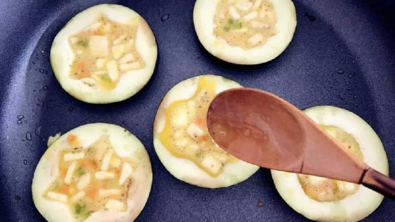 宝宝辅食:茄子圈蛋饼,用勺子将步骤5中准备好的鸡蛋液舀入茄子圈内,注意不要放太满,九分满即可,后面加热过程中鸡蛋液会稍稍膨胀,太满溢出影响最终成品颜值哈!
》鸡蛋液一般是用不完的,可以直接煎成蛋饼吃,里面有软软的茄子丁,味道也很棒。