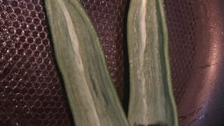 安其拉达(Enchiladas chicken)墨西哥菜,平底锅上抹点油,把辣椒对半切开,带皮的那面放在不粘锅上小火慢煎。
