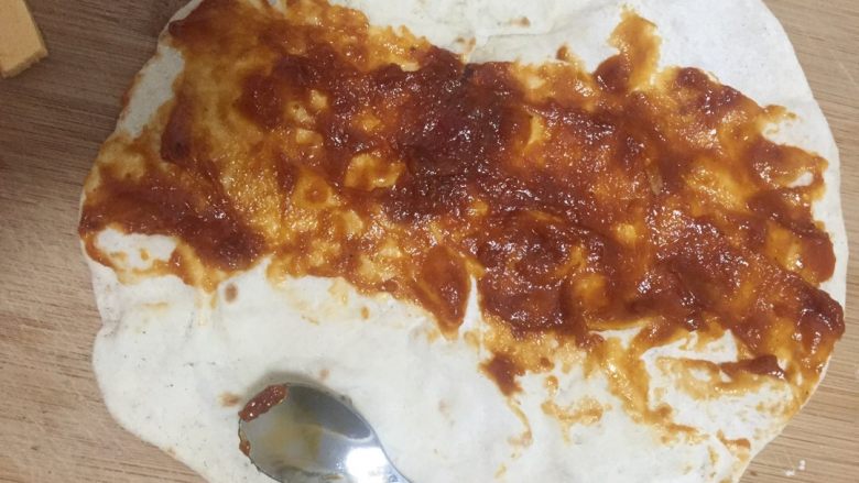 安其拉达(Enchiladas chicken)墨西哥菜,拿一张墨西哥薄饼,饼中间抹上安其拉达酱汁,抹匀